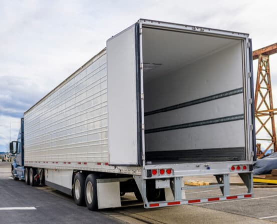 Semi truck with its dry van trailer doors open, ready for loading