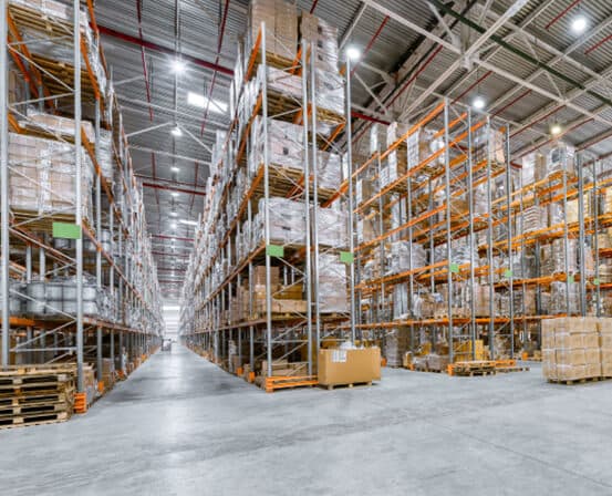 High-bay warehouse aisle with palletized goods on multi-level racking